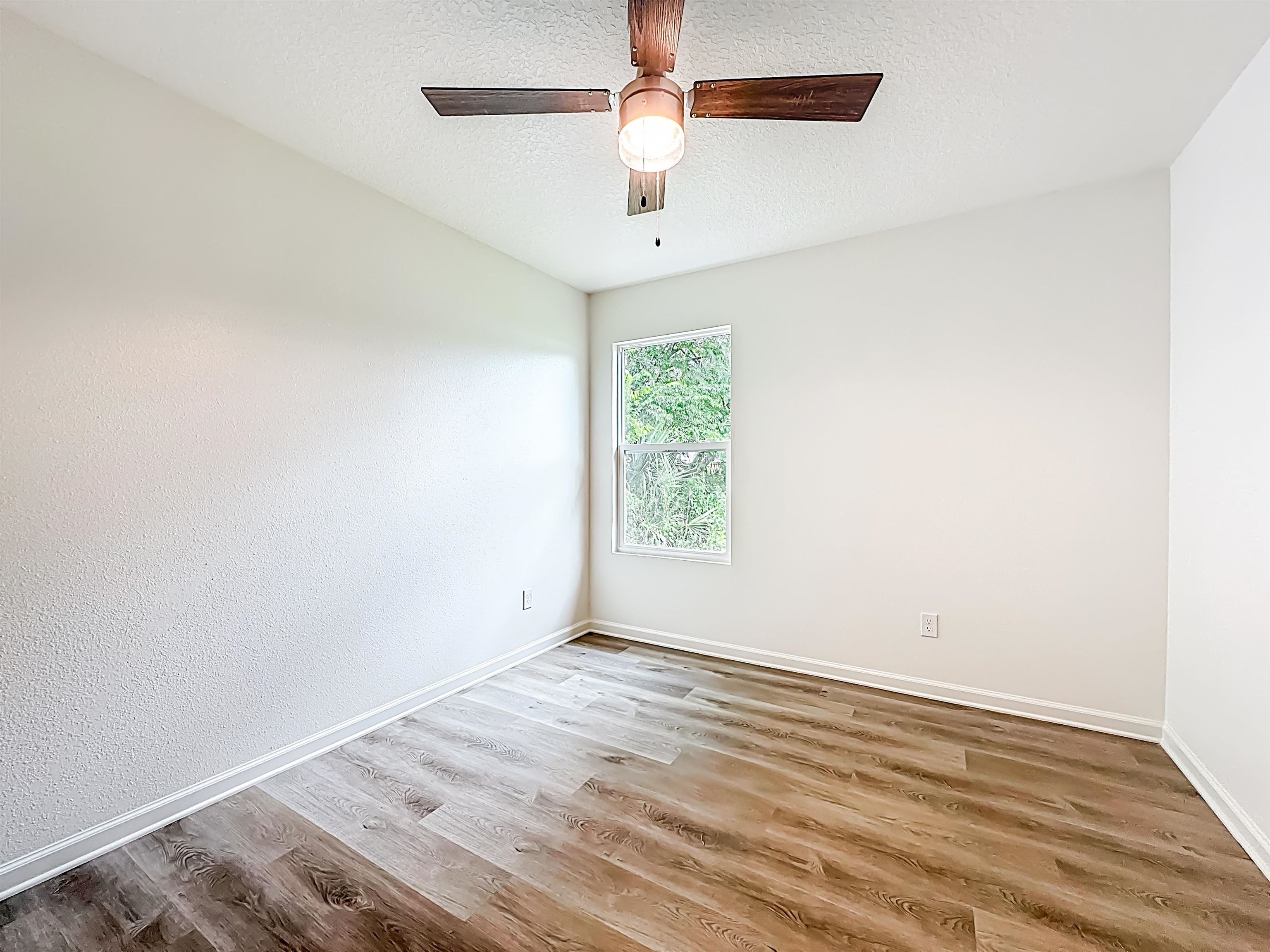 780 West 5th Street St. Augustine, FL 32084 - Photo 18 of 30 an empty room with wooden floor ceiling fan and windows