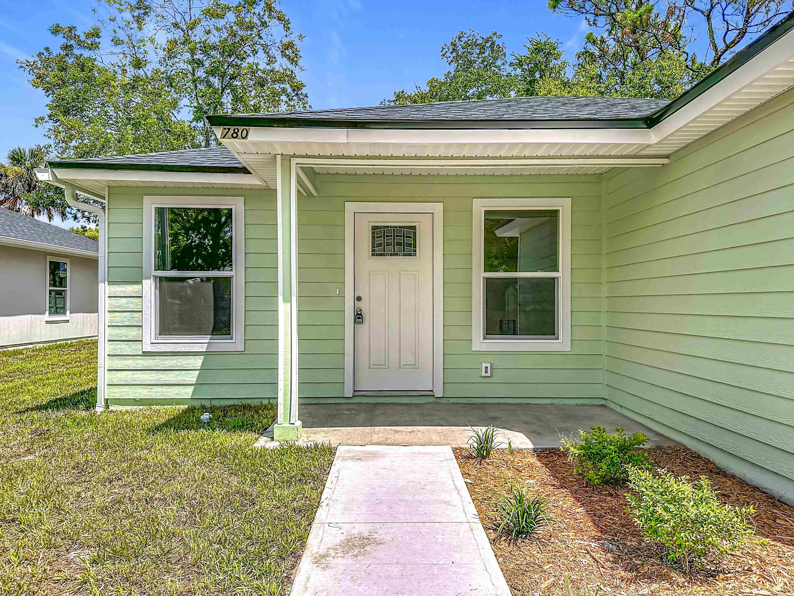 780 West 5th Street St. Augustine, FL 32084 - Photo 2 of 30 a front view of a house with a garden