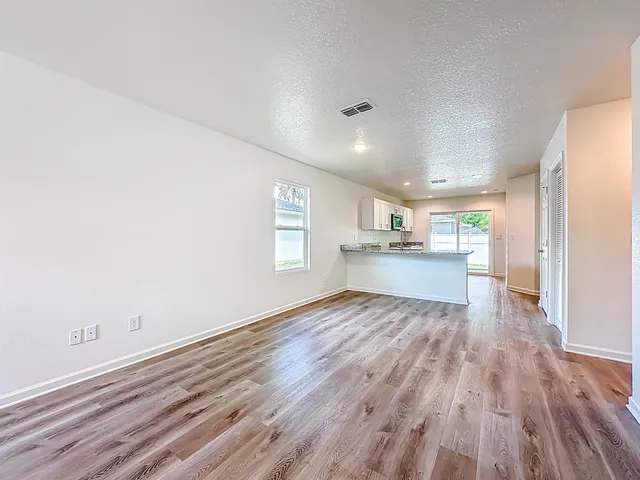 a view of a kitchen with wooden floor and a window