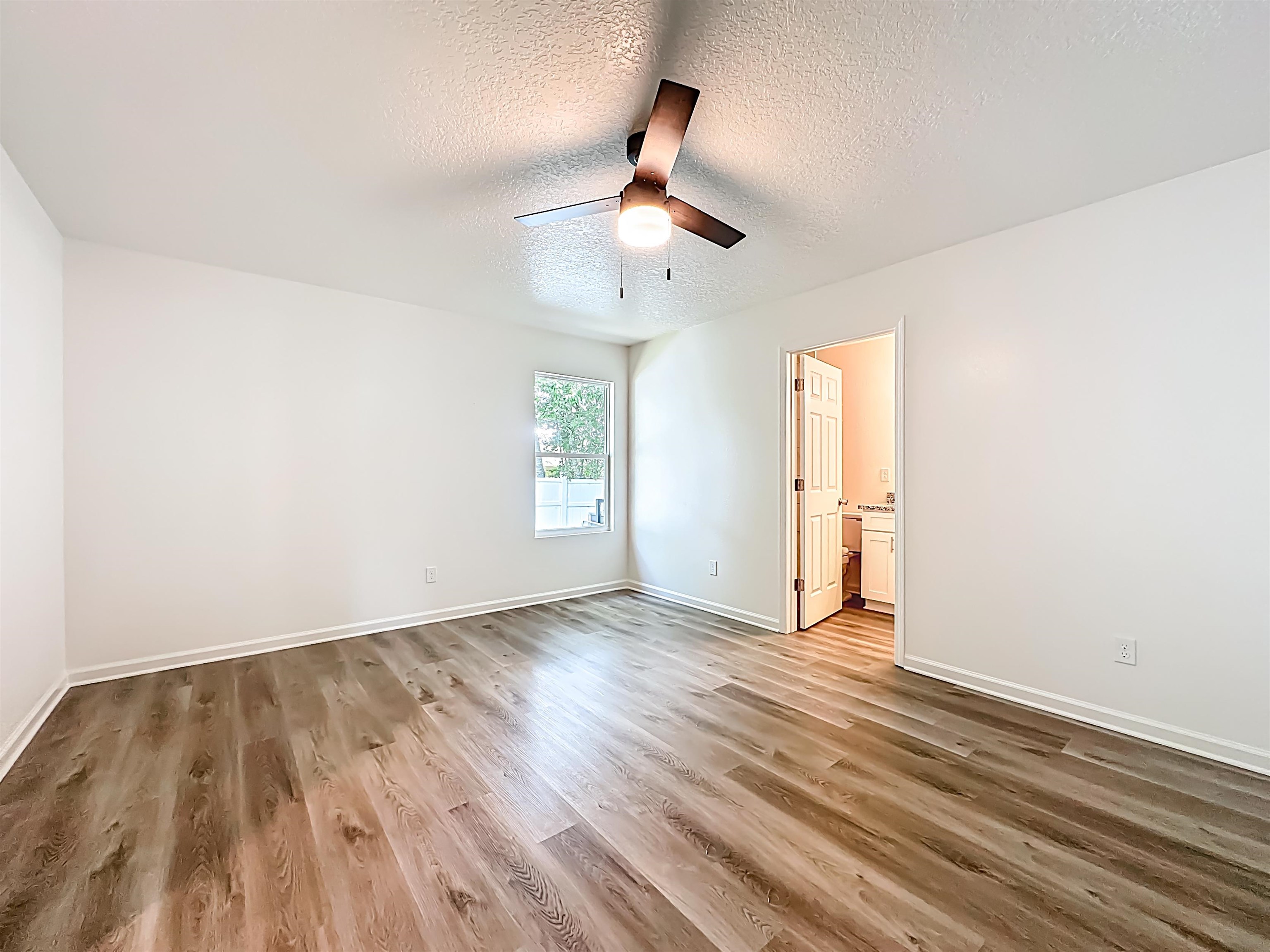 780 West 5th Street St. Augustine, FL 32084 - Photo 10 of 30 an empty room with wooden floor ceiling fan and windows