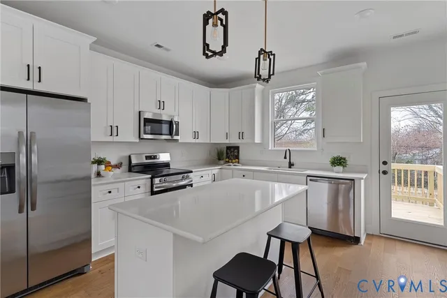 a kitchen with stainless steel appliances a refrigerator sink and microwave