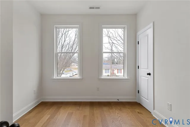 a view of empty room with wooden floor