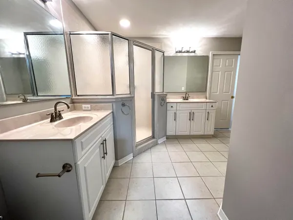 a bathroom with a double vanity sink mirror and shower