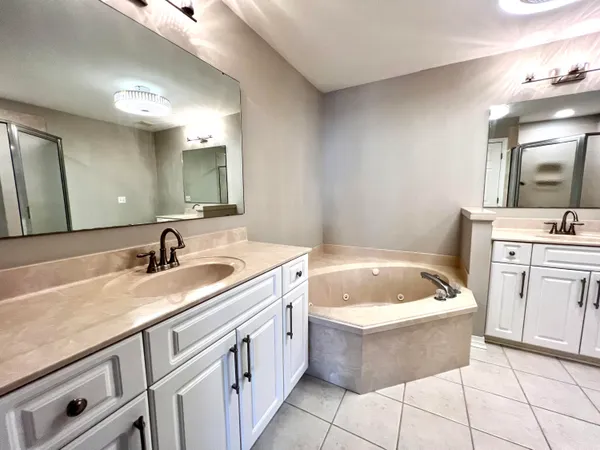 a bathroom with a granite countertop bathtub sink and mirror