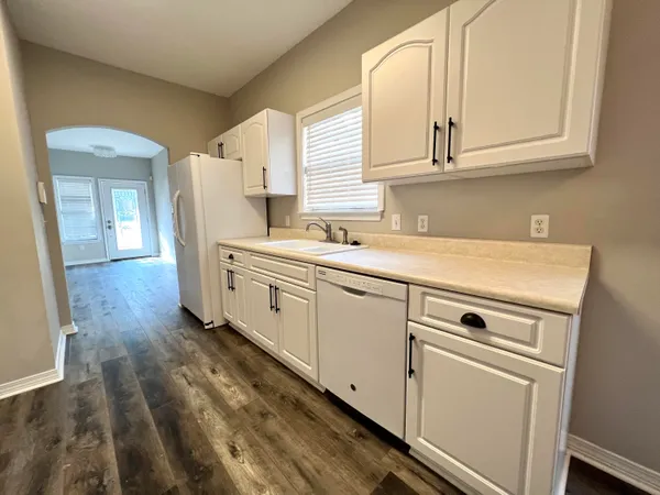 a view of a kitchen with sink and dishwasher with wooden floor