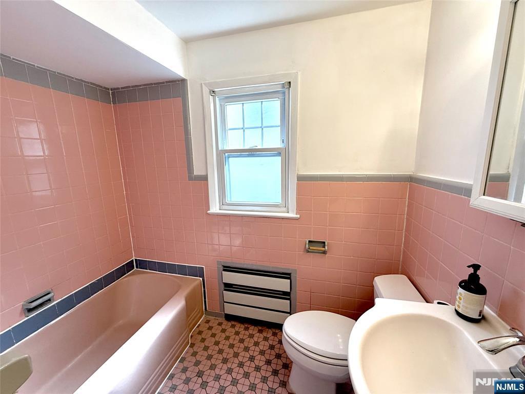 175 Van Winkle Street, Unit 2 East Rutherford, NJ 07073 - Photo 19 of 20 a bathroom with a sink a toilet and tub