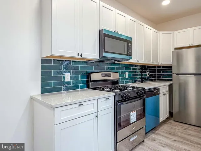 a kitchen with a refrigerator a stove and a microwave