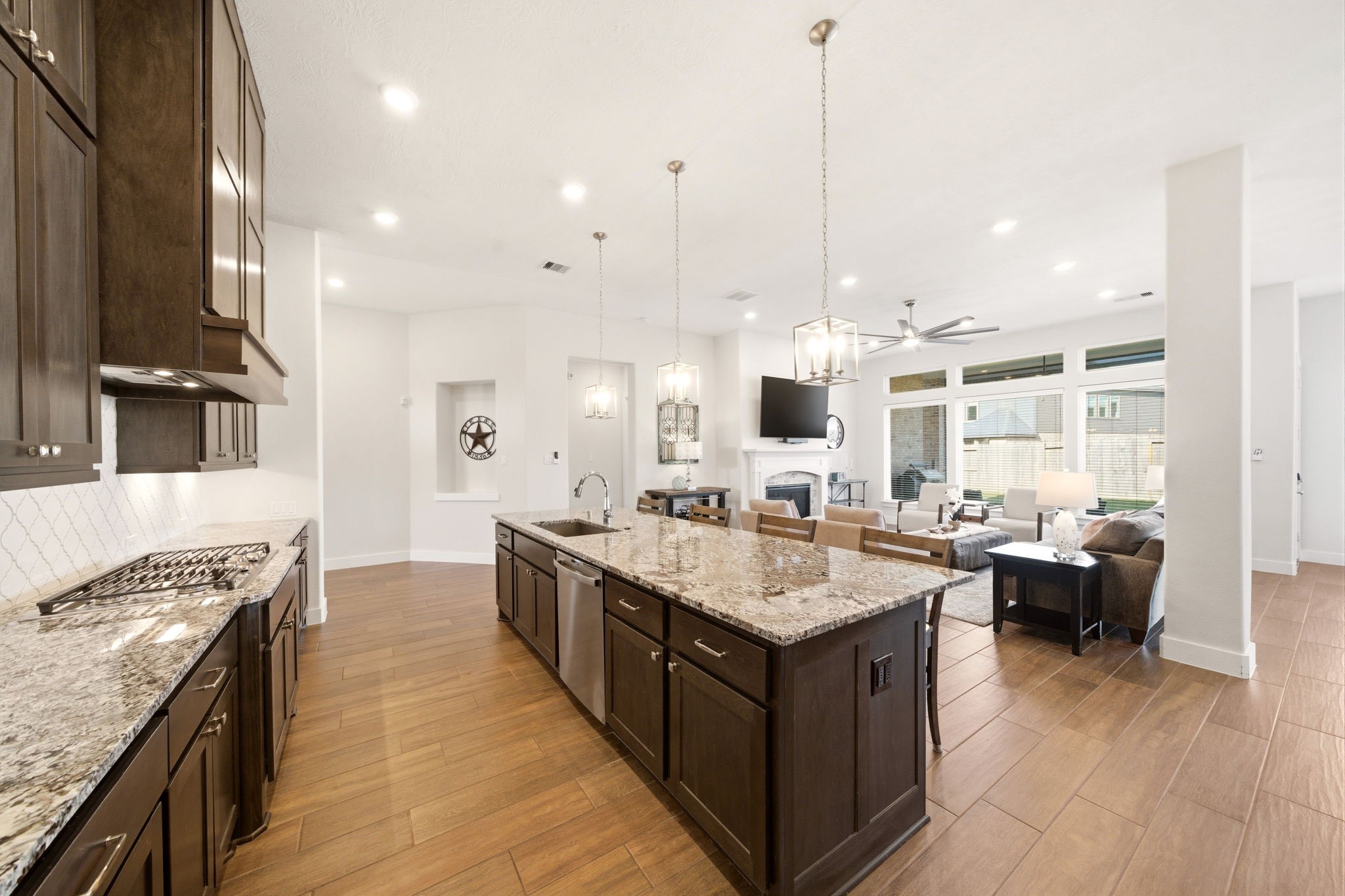 28811 Ember Crest Lane Fulshear, TX 77441 - Photo 15 of 47 a large kitchen with kitchen island a stove a sink dishwasher and a dining table with wooden floor