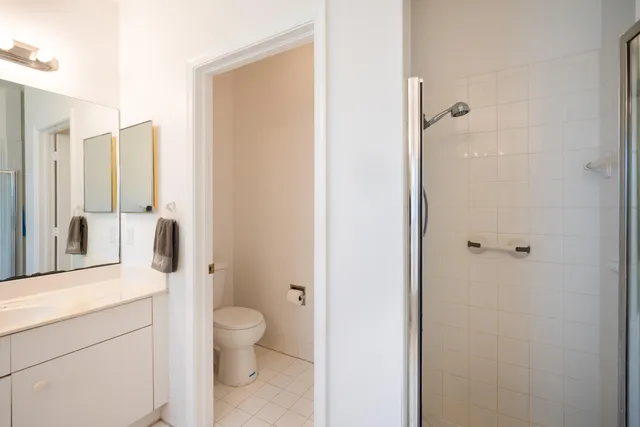 a bathroom with a granite countertop toilet a sink and a mirror