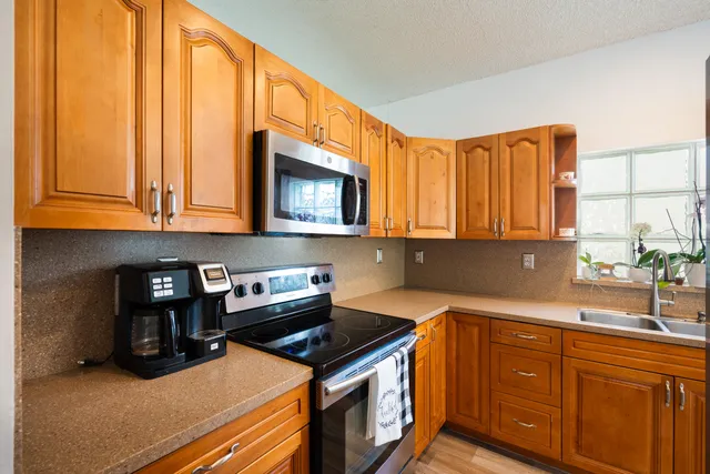 a kitchen with stainless steel appliances granite countertop a stove a sink and a microwave