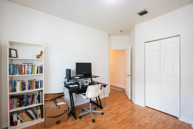 a view of a workspace with bookshelf and a window