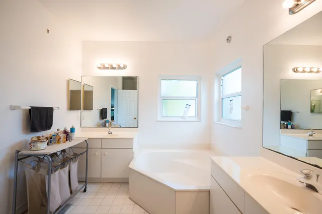 a bathroom with a sink double vanity granite tub and a mirror