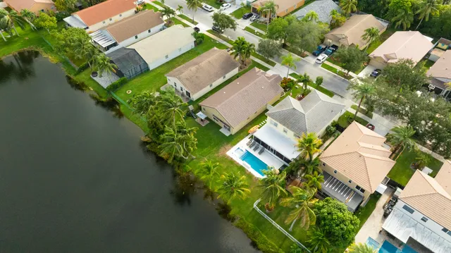 an aerial view of a house with a yard and lake view