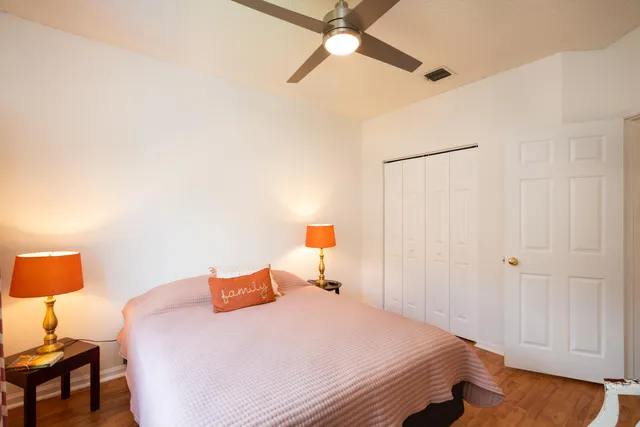 a bedroom with a bed and a lamp on a dresser