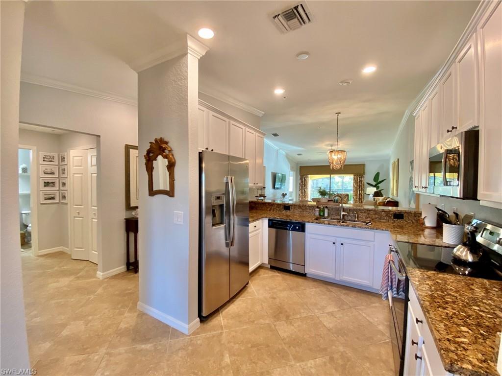 a view of a kitchen with refrigerator and windows