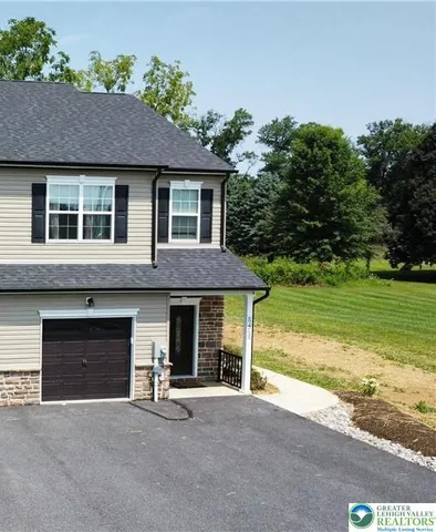 a front view of a house with a garden and yard