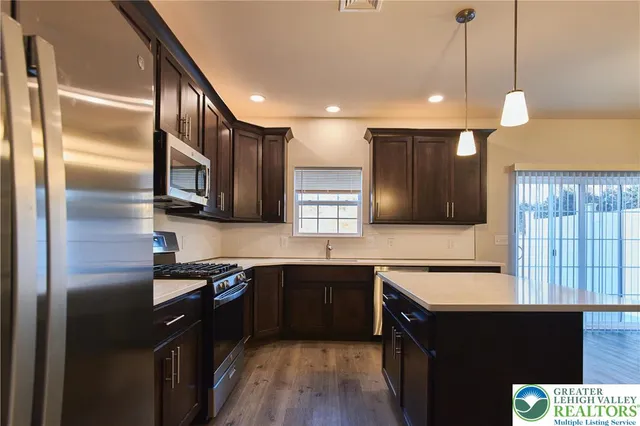a kitchen with stainless steel appliances granite countertop a sink a stove and a refrigerator