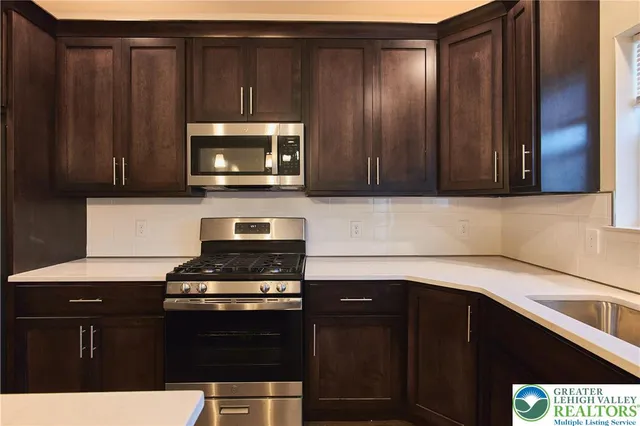 a kitchen with granite countertop a stove and a microwave