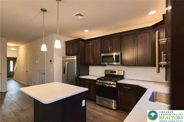 a kitchen with kitchen island a sink stainless steel appliances and cabinets