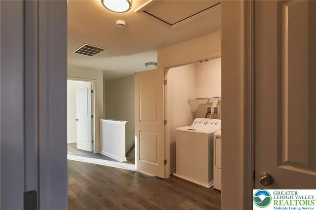 a view of a hallway with bathroom and wooden floor