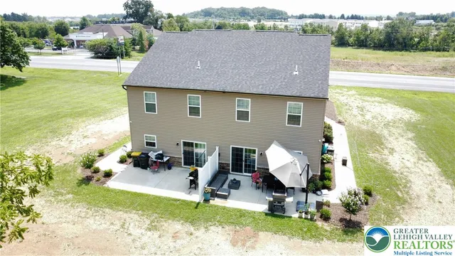 a aerial view of a house with swimming pool and large trees
