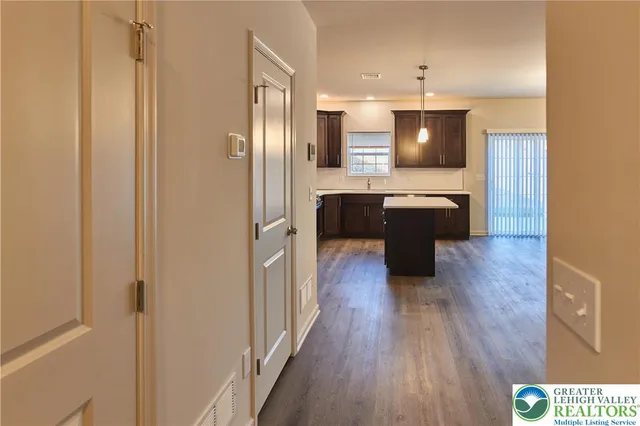 a kitchen with kitchen island wooden floor center island and stainless steel appliances