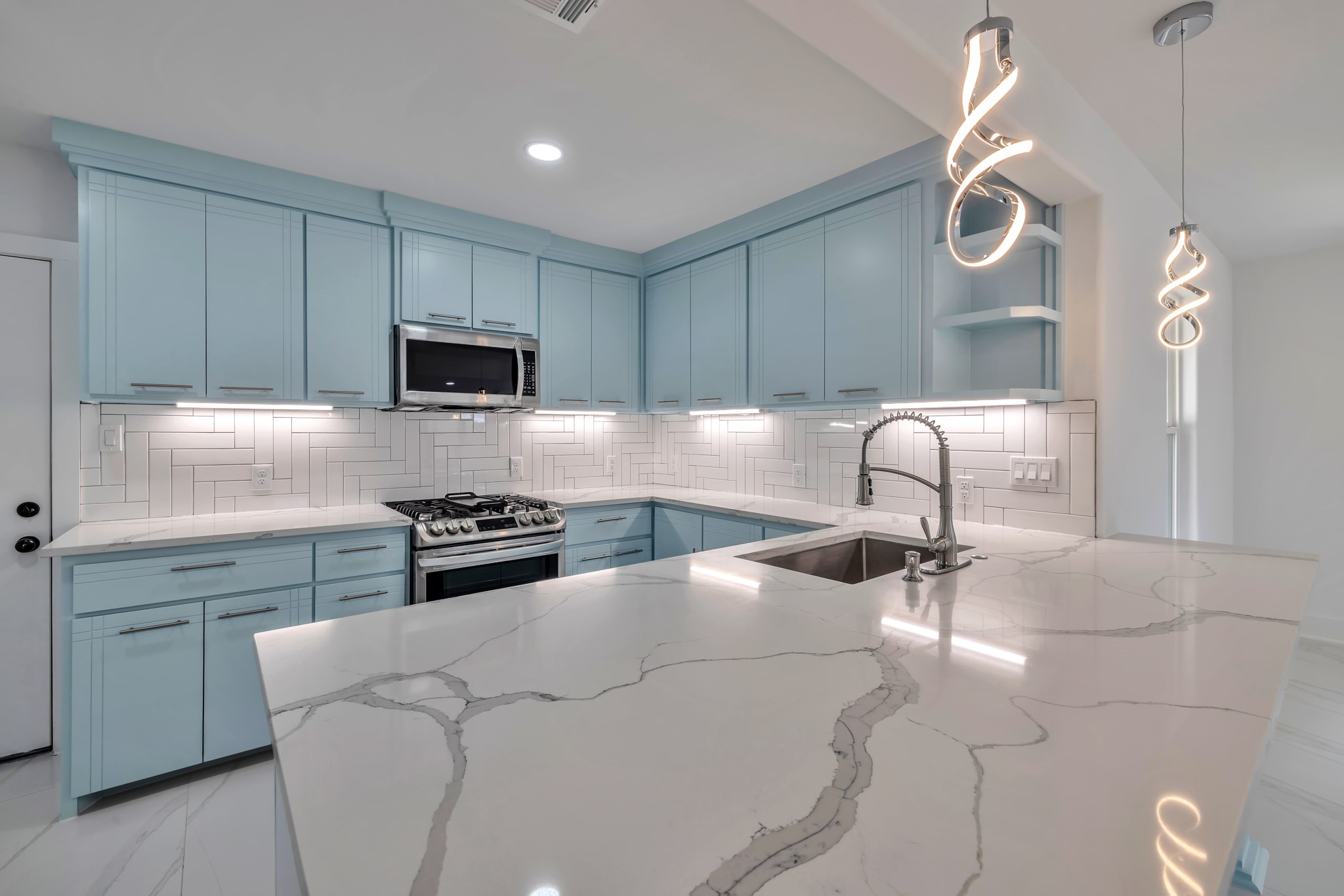 8709 Tarbell Road Houston, TX 77034 - Photo 9 of 25 a kitchen with granite countertop a stove a sink and a microwave