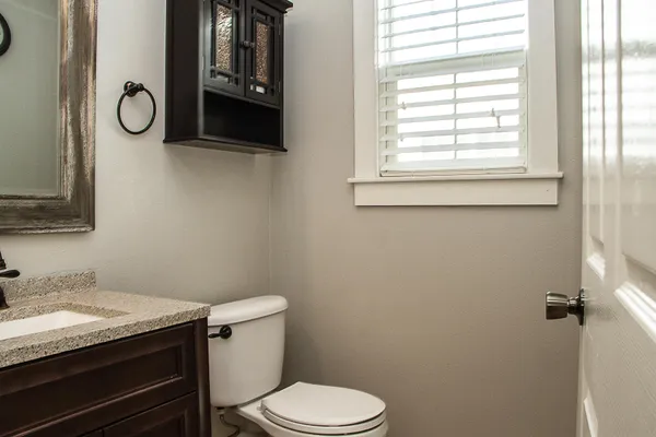 a bathroom with a granite countertop toilet and a sink