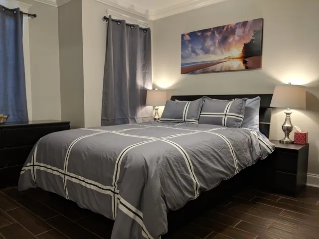 a bedroom with a bed and a painting on the wall