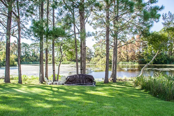 a view of a lake with a bench and a yard