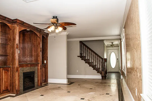 a view of a hallway with wooden floor staircase and a kitchen
