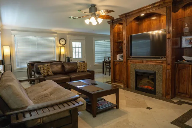 a living room with furniture a flat screen tv and a fireplace