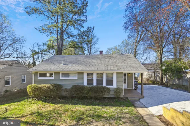 a front view of a house with a yard covered in snow