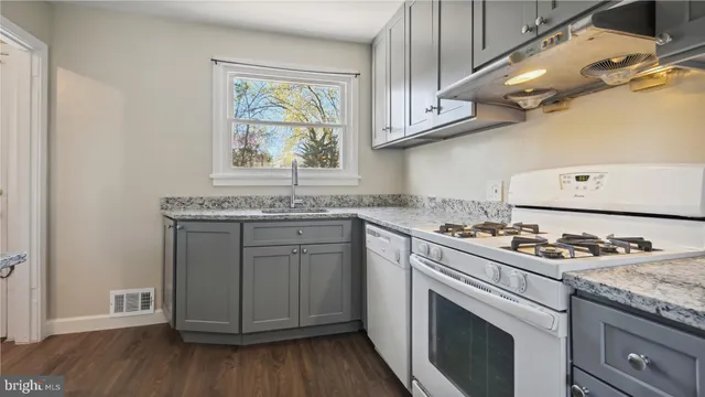 a kitchen with granite countertop cabinets stainless steel appliances and wooden floor