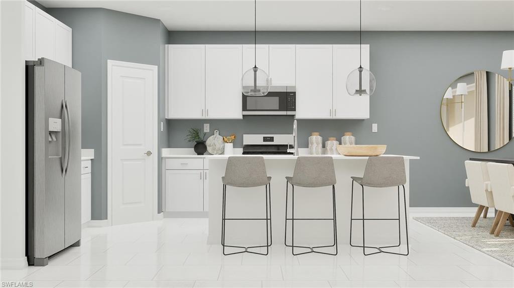 14895 Bluewater Road Babcock Ranch, FL 33982 - Photo 4 of 27 a kitchen with stainless steel appliances granite countertop a refrigerator a sink a stove and white cabinets