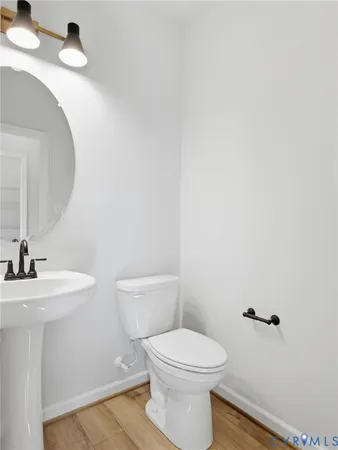 a bathroom with a toilet a sink and mirror
