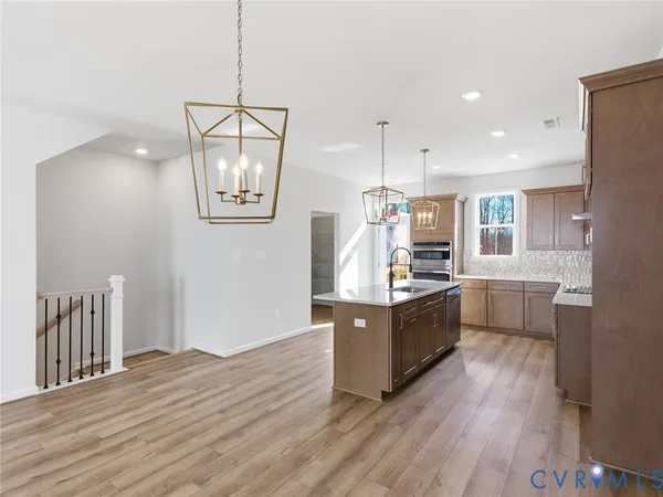 a kitchen with stainless steel appliances wooden floor and large windows