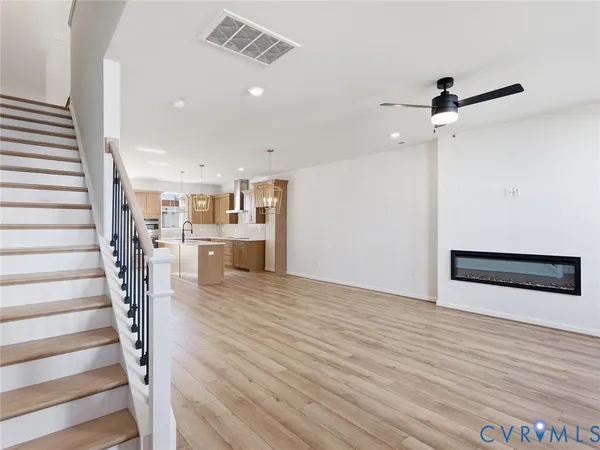 an empty room with wooden floor and ceiling fan