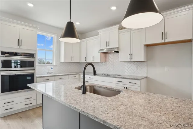 a kitchen with white cabinets a sink and dishwasher