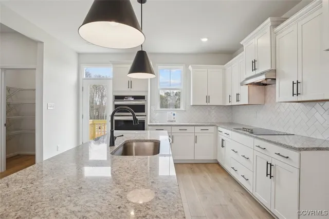 a kitchen with granite countertop a sink stainless steel appliances and cabinets