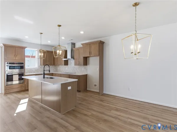 a large kitchen with granite countertop a large counter top a sink stainless steel appliances and cabinets