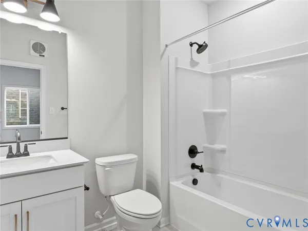 a bathroom with a bathtub shower sink vanity and toilet