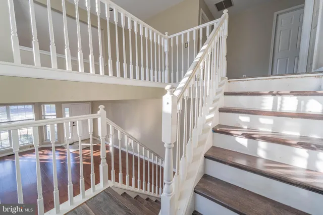 a view of staircase with lots of frames on wall and a window