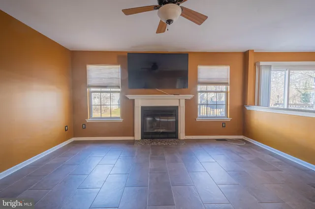 wooden floor fireplace and windows in an empty room