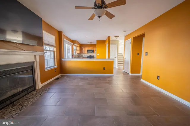 a view of an empty room with a fireplace and a window
