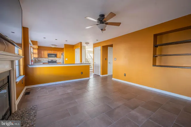 a view of an empty room with a fireplace and a window