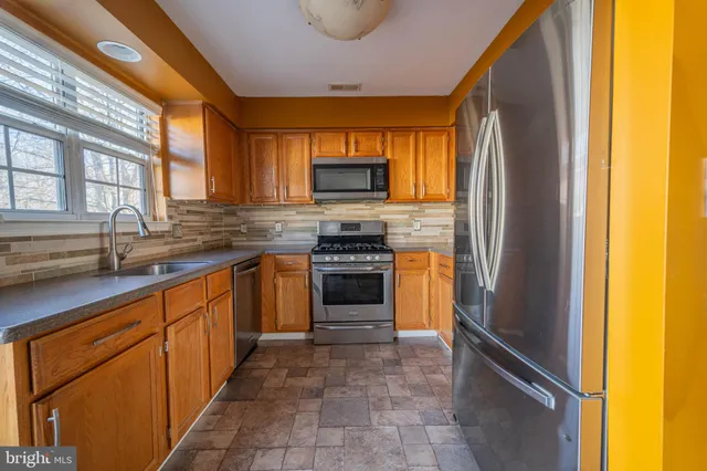a kitchen with stainless steel appliances granite countertop a stove and a refrigerator