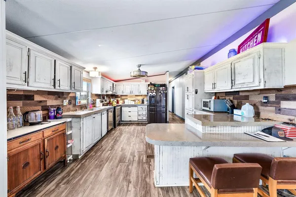 a kitchen with granite countertop a refrigerator and wooden cabinets