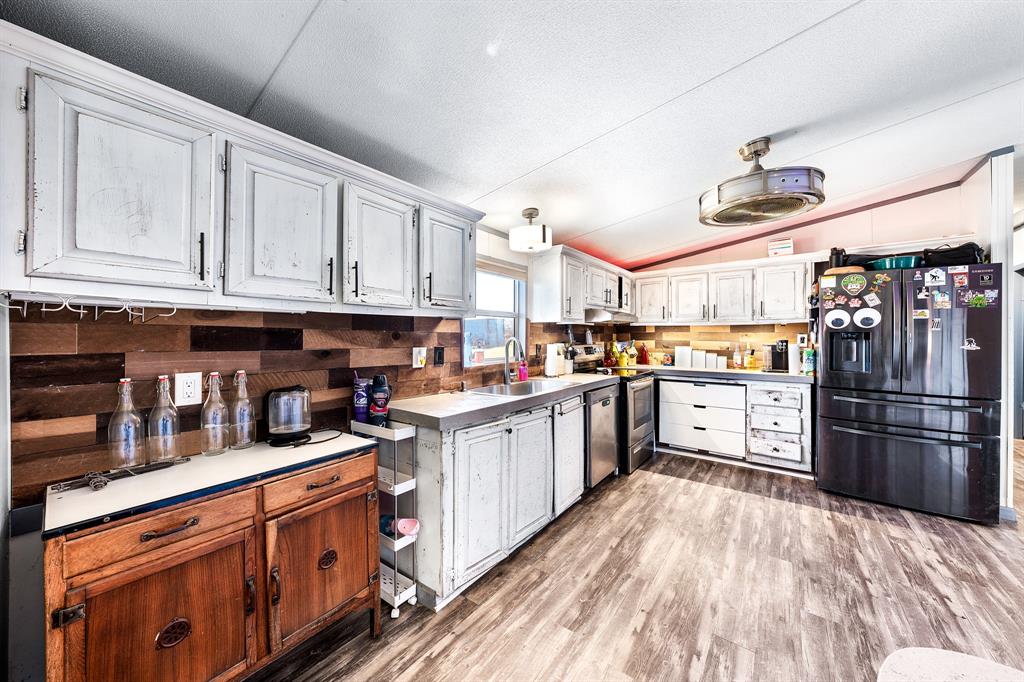 1536 New Hope Road Boyd, TX 76023 - Photo 26 of 40 a kitchen with granite countertop a refrigerator and wooden cabinets