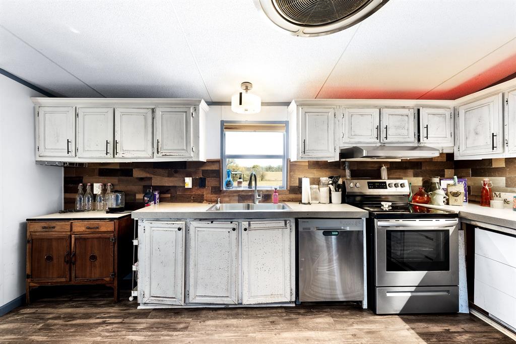 1536 New Hope Road Boyd, TX 76023 - Photo 28 of 40 a kitchen with stainless steel appliances granite countertop a stove sink and cabinets